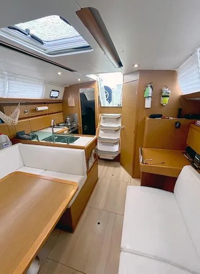 Escape Yacht Photos Pics Interior of 2018 Jeanneau Sun Odyssey 389 sailboat with modern wood finish and seating area.