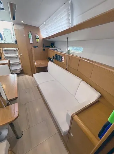 Escape Yacht Photos Pics Interior of 2018 Jeanneau Sun Odyssey 389 yacht with white sofa and wooden accents.