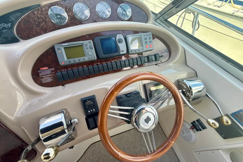 Off The Air Yacht Photos Pics Helm of 2004 Sea Ray 380 Sundancer with wooden steering wheel and navigation instruments.