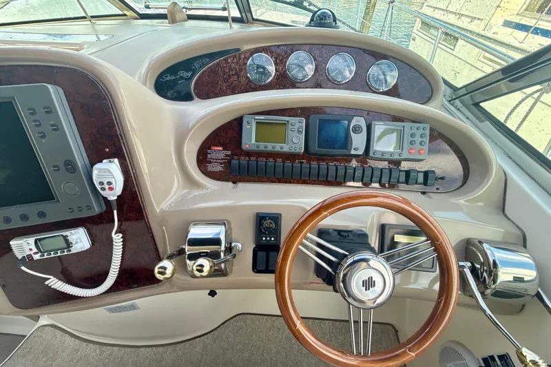 Off The Air Yacht Photos Pics 2004 Sea Ray 380 Sundancer helm with navigation instruments and wooden steering wheel.