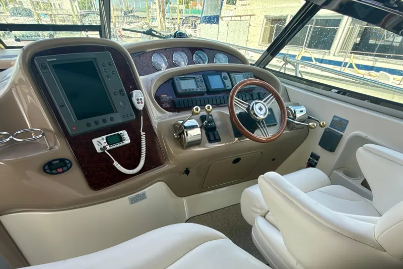 Off The Air Yacht Photos Pics 2004 Sea Ray 380 Sundancer helm with steering wheel, navigation controls, and comfortable seating.
