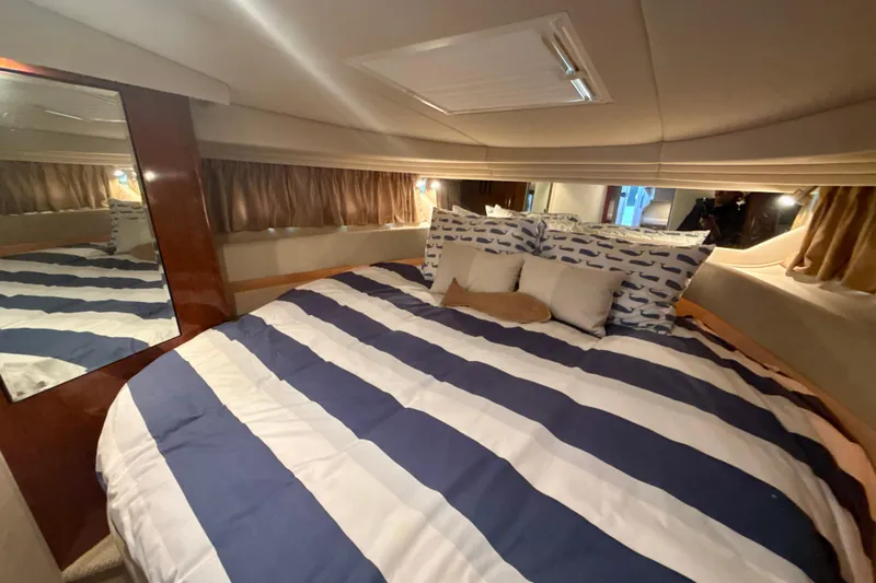 Off The Air Yacht Photos Pics Luxurious cabin interior of 2004 Sea Ray 380 Sundancer with striped bedding and cozy pillows.