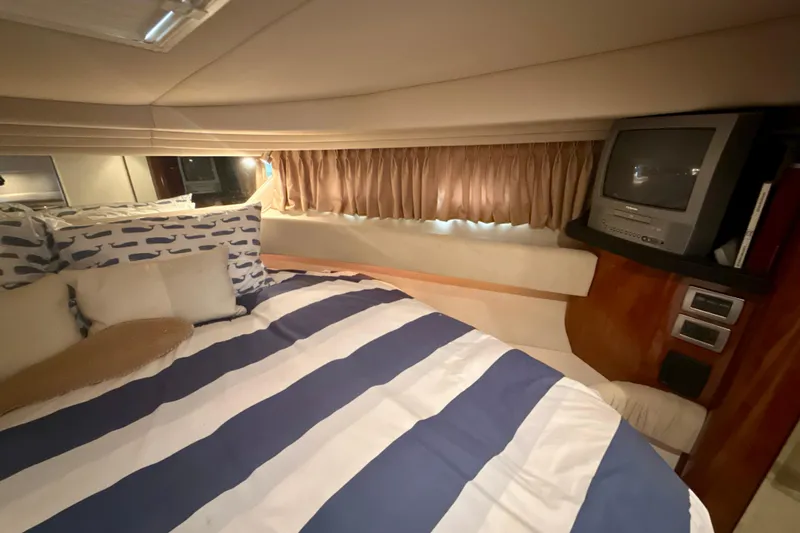 Off The Air Yacht Photos Pics 2004 Sea Ray 380 Sundancer cabin with striped bedding and vintage TV.