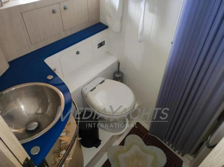  Yacht Photos Pics 2005 Uniesse 48 Open yacht bathroom with sink, toilet, and blue countertop.