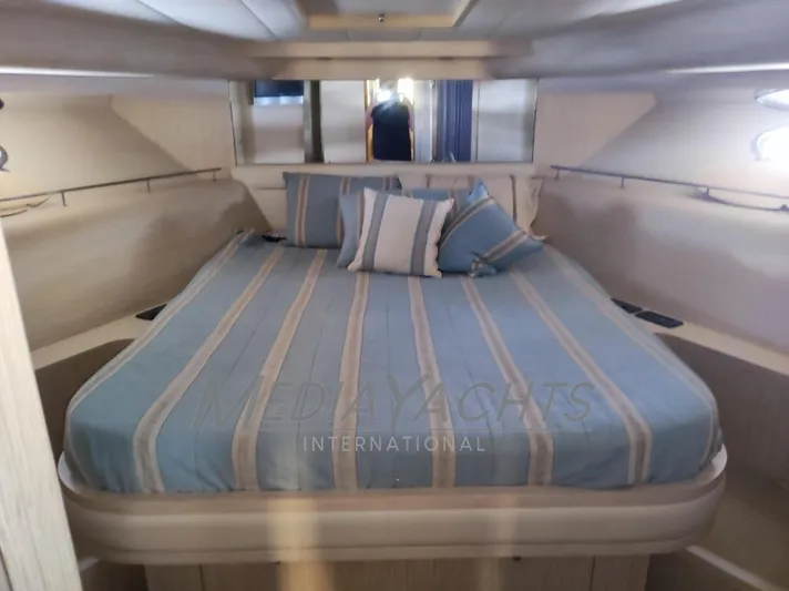  Yacht Photos Pics Luxurious cabin interior of 2005 Uniesse 48 Open yacht with striped bedding.