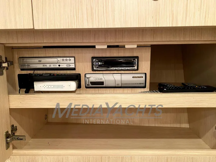  Yacht Photos Pics Entertainment system in a 2005 Uniesse 48 Open yacht, featuring media players and remotes.