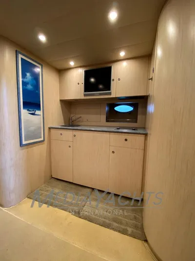  Yacht Photos Pics 2005 Uniesse 48 Open yacht interior with modern kitchenette and sleek wood finish.