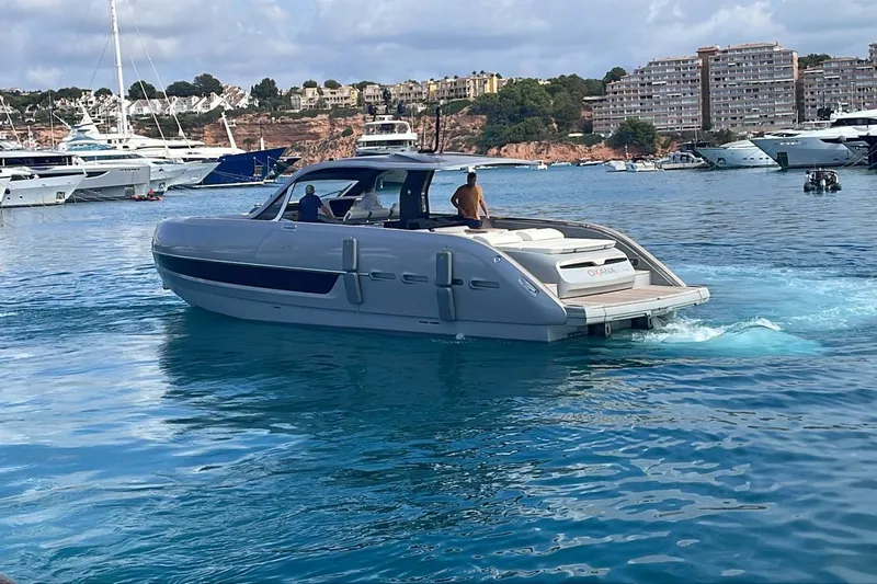  Yacht Photos Pics 2021 Invictus TT460 yacht cruising in a scenic marina with luxury boats.