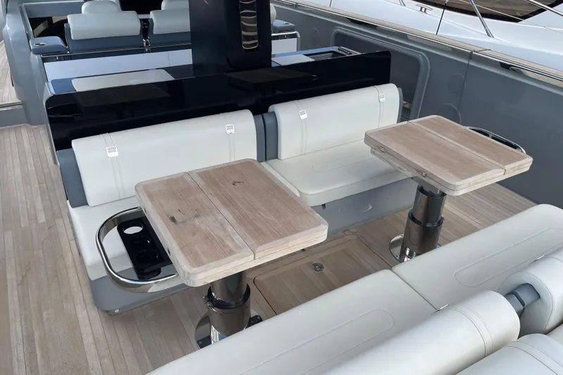  Yacht Photos Pics Luxurious seating area on 2021 Invictus TT460 yacht with wooden tables and modern design.