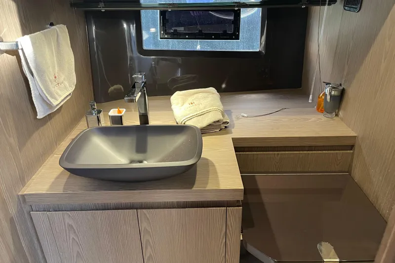 Yacht Photos Pics Modern bathroom interior of 2021 Invictus TT460 yacht with sleek sink and wooden cabinetry.