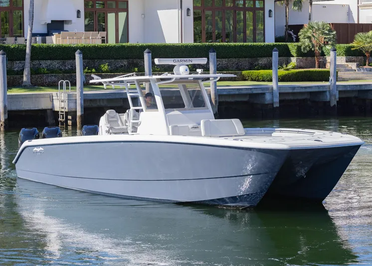  Yacht Photos Pics 2019 Invincible 37 Catamaran in water, sleek design, docked near waterfront property.