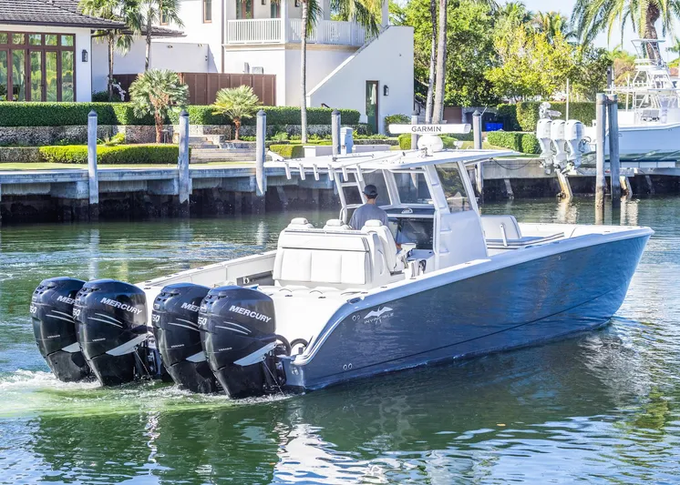  Yacht Photos Pics 2019 Invincible 37 Catamaran with four Mercury engines cruising in a scenic waterfront setting.