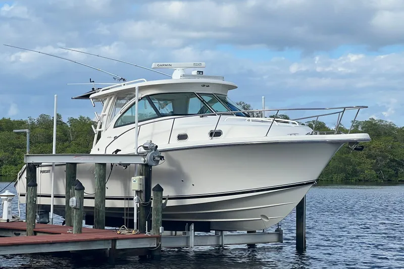 Little Solace Yacht Photos Pics 2012 Pursuit OS 345 Offshore boat docked on a calm lake.