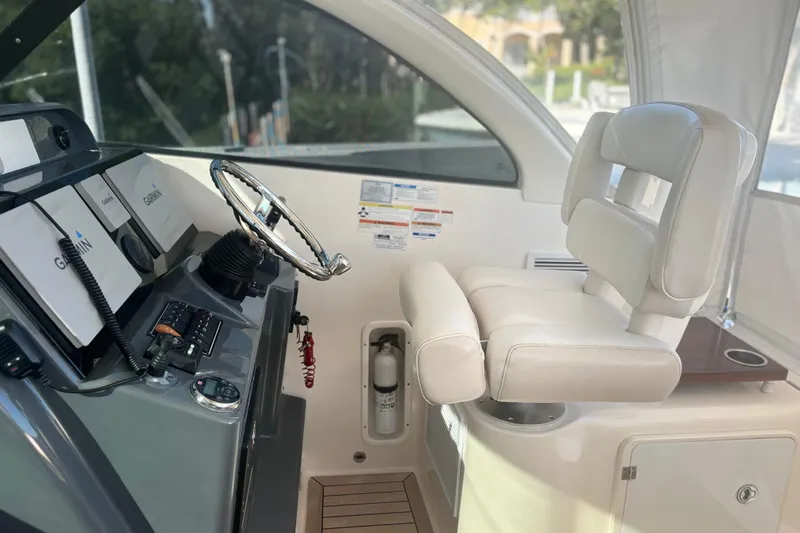 Little Solace Yacht Photos Pics Helm of 2012 Pursuit OS 345 Offshore boat with Garmin navigation system and white captain's chair.