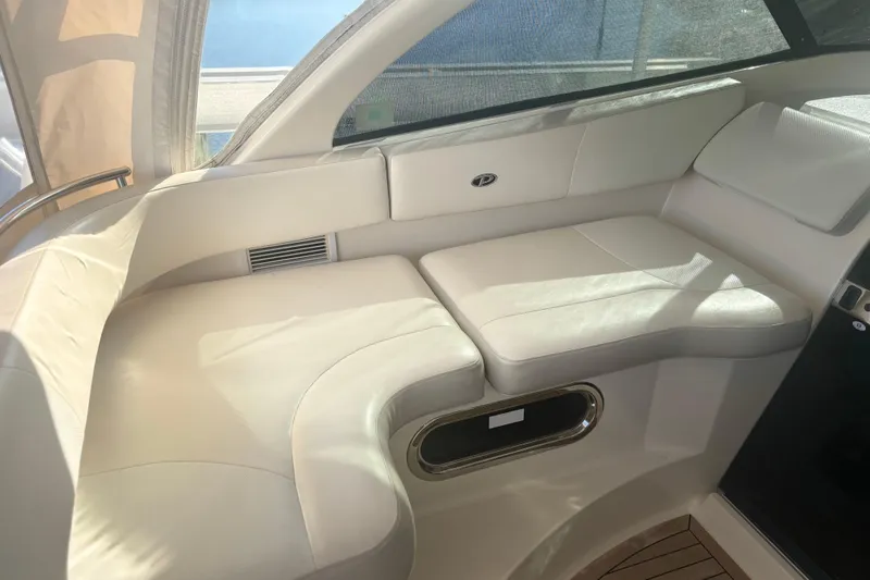 Little Solace Yacht Photos Pics Luxurious interior seating of 2012 Pursuit OS 345 Offshore boat, featuring cream leather upholstery.