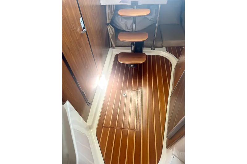 Little Solace Yacht Photos Pics 2012 Pursuit OS 345 Offshore cabin interior with wooden flooring and steps.