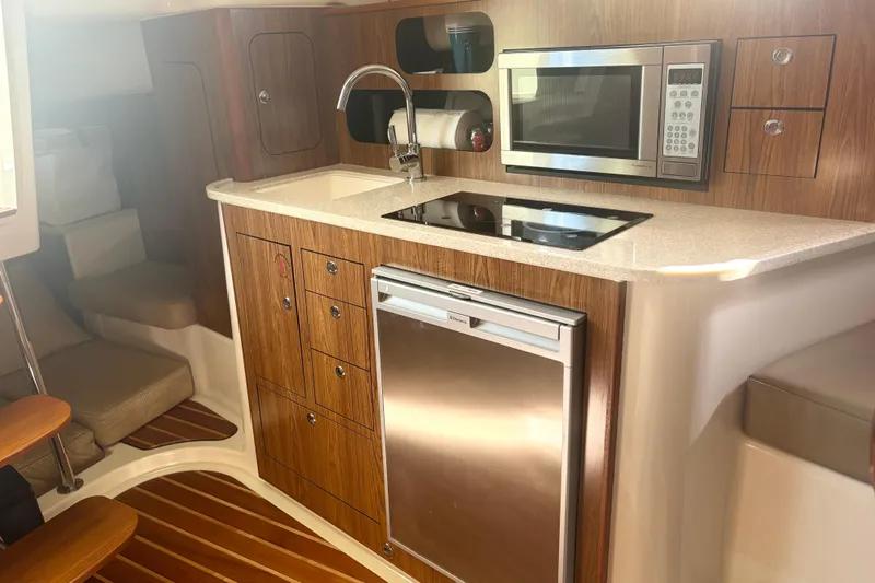 Little Solace Yacht Photos Pics Luxurious 2012 Pursuit OS 345 Offshore yacht kitchen with modern appliances and wood finish.