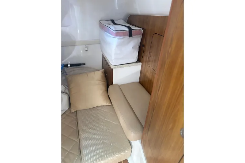 Little Solace Yacht Photos Pics 2012 Pursuit OS 345 Offshore cabin interior with cushions and storage.