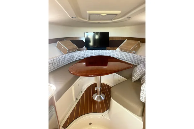 Little Solace Yacht Photos Pics 2012 Pursuit OS 345 Offshore cabin interior with TV, table, and seating.