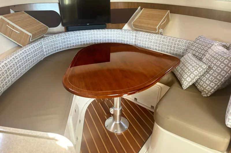 Little Solace Yacht Photos Pics Luxurious interior of 2012 Pursuit OS 345 Offshore boat with elegant wood table and seating.