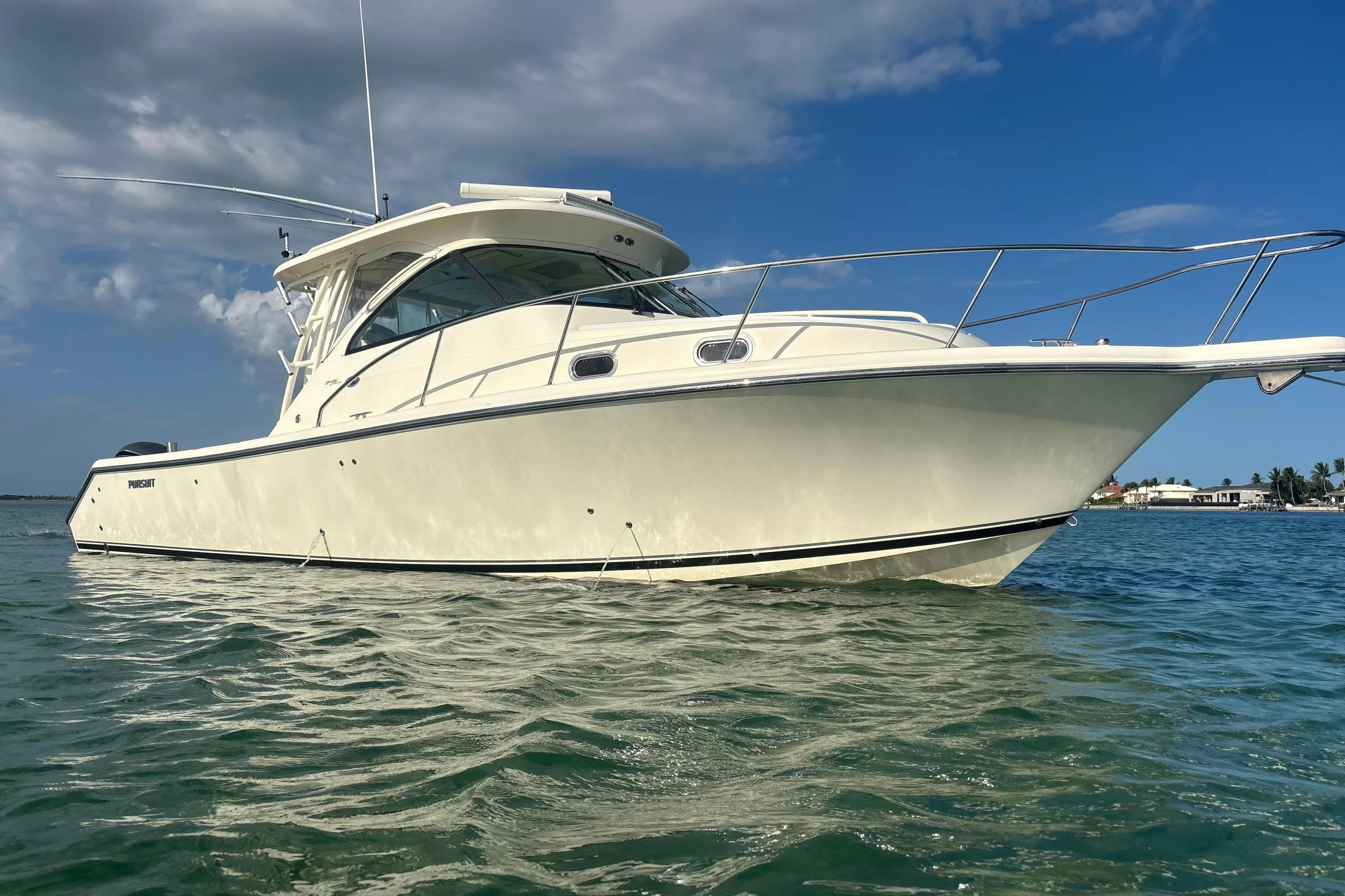 2012 Pursuit OS 345 Offshore boat on calm water under a partly cloudy sky.