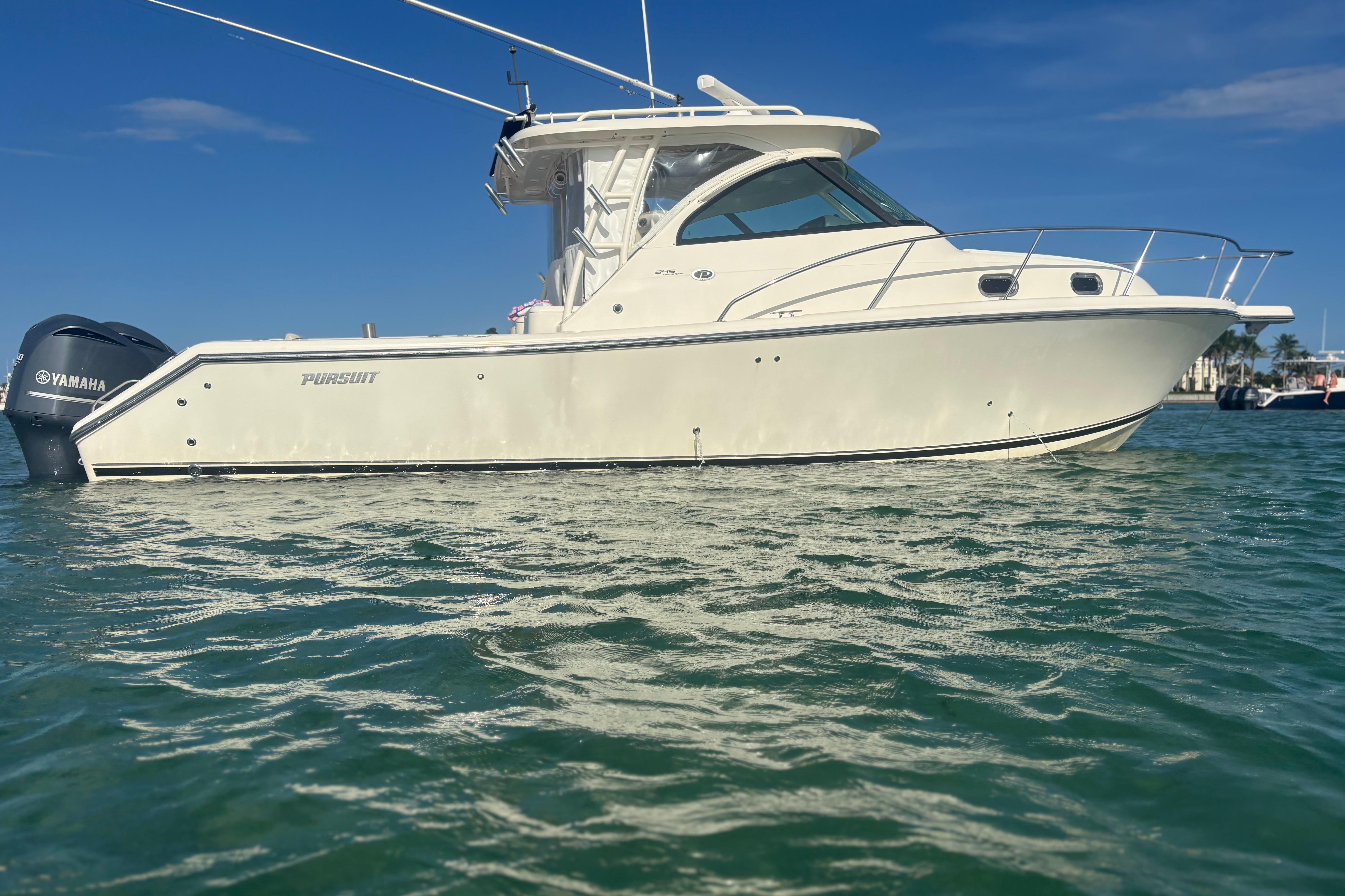 2012 Pursuit OS 345 Offshore boat on water, clear sky background.
