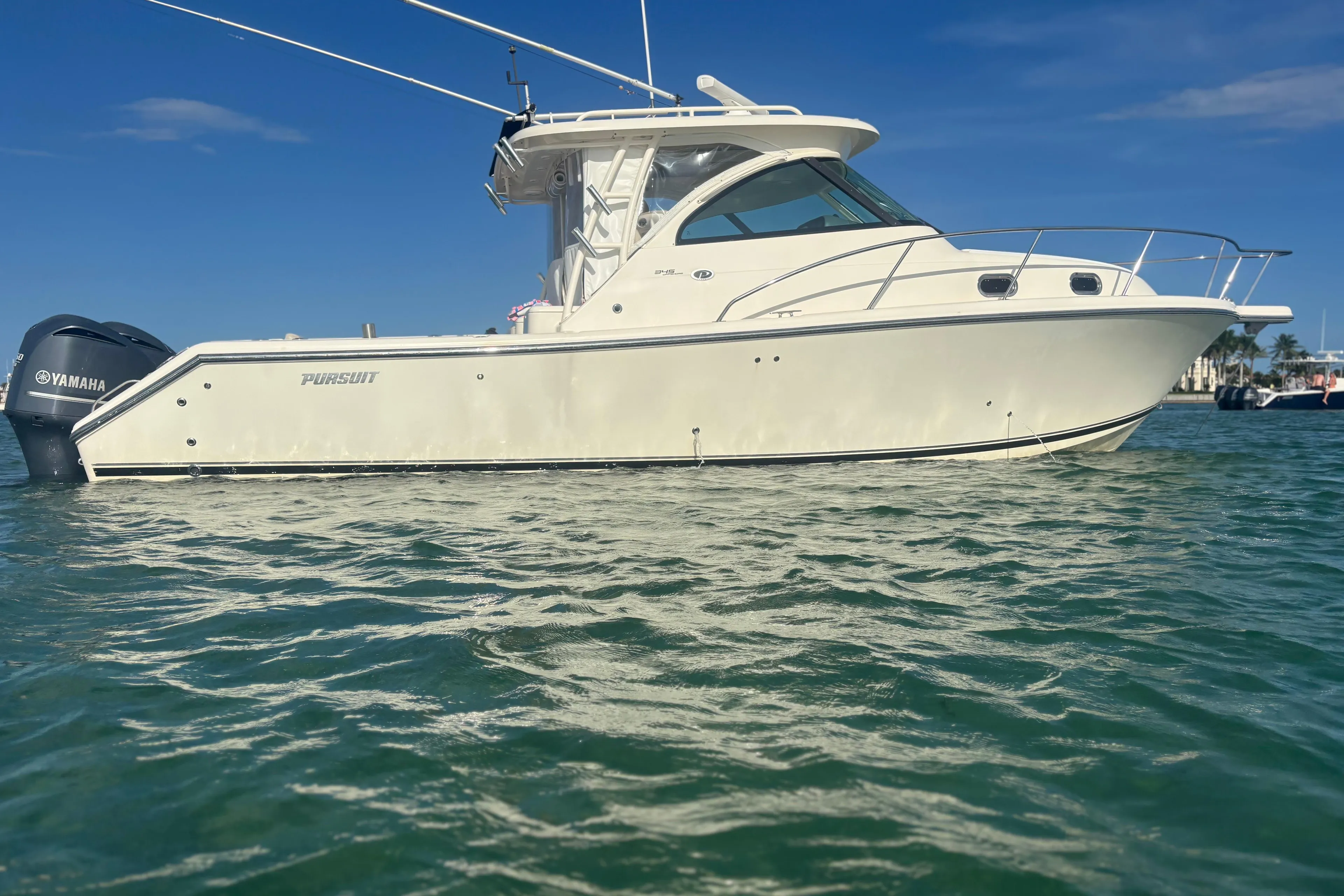 2012 Pursuit OS 345 Offshore boat on water, clear sky background.