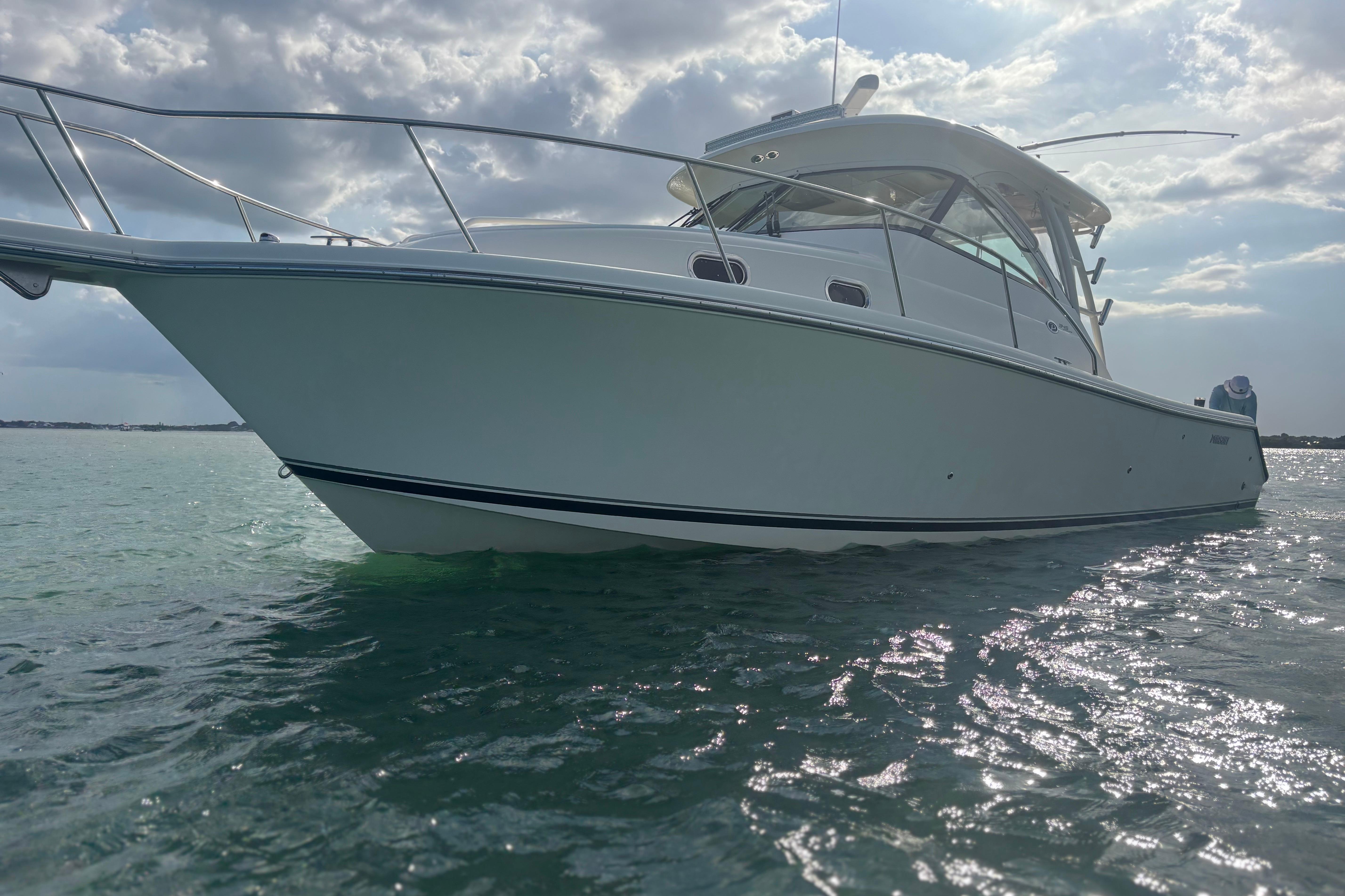 2012 Pursuit OS 345 Offshore boat on calm water under cloudy sky.