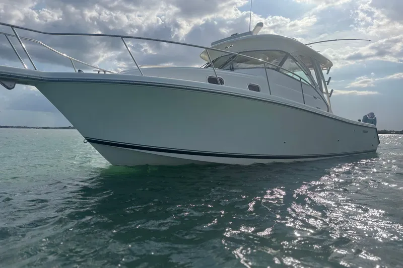 Little Solace Yacht Photos Pics 2012 Pursuit OS 345 Offshore boat on calm water under cloudy sky.