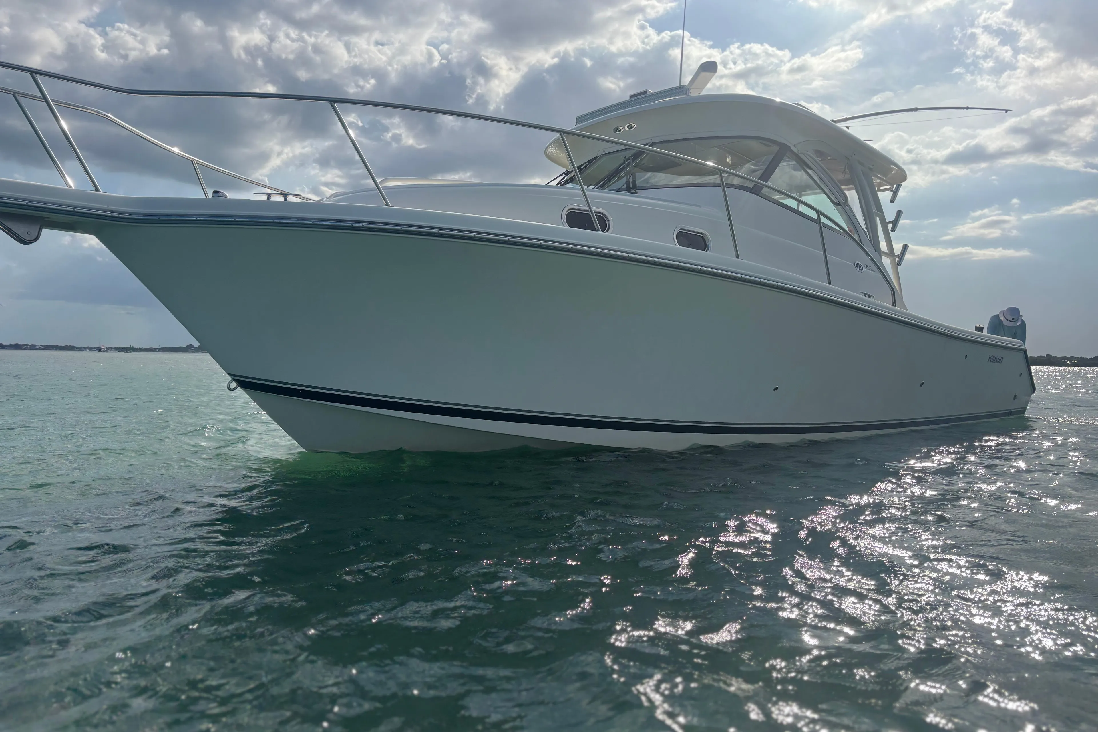 2012 Pursuit OS 345 Offshore boat on calm water under cloudy sky.