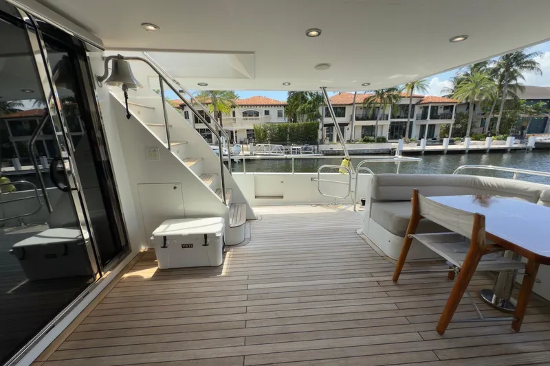 Family Time Yacht Photos Pics Luxurious 2006 Cheoy Lee 84 Bravo yacht deck with seating, table, and waterfront view.