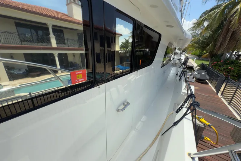 Family Time Yacht Photos Pics 2006 Cheoy Lee 84 Bravo yacht docked beside a luxurious waterfront property.