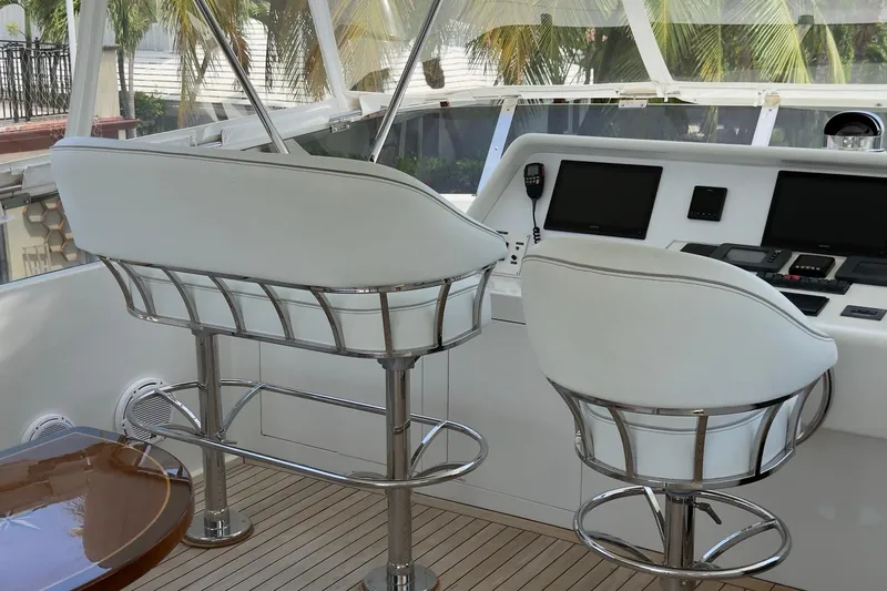 Family Time Yacht Photos Pics Helm station of 2006 Cheoy Lee 84 Bravo yacht with white seating and control panels.