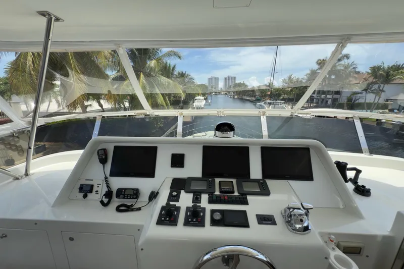 Family Time Yacht Photos Pics Helm of 2006 Cheoy Lee 84 Bravo yacht with navigation equipment, overlooking a scenic waterway.