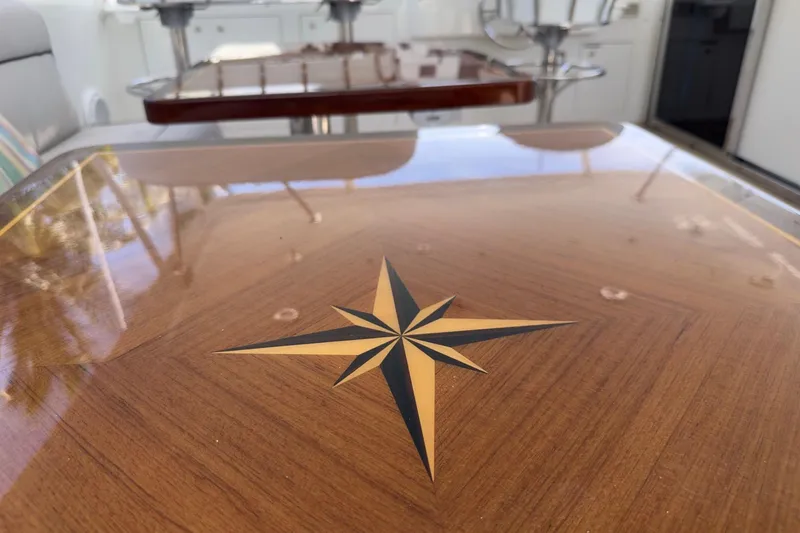 Family Time Yacht Photos Pics Polished wooden table with compass rose design on 2006 Cheoy Lee 84 Bravo yacht.