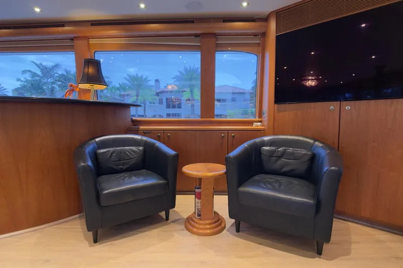 Family Time Yacht Photos Pics Interior of 2006 Cheoy Lee 84 Bravo yacht with leather chairs and wooden decor.
