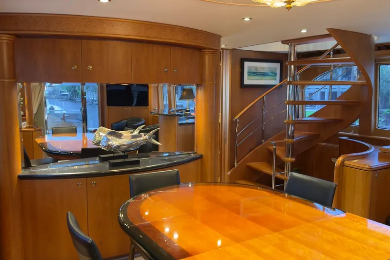 Family Time Yacht Photos Pics Luxurious interior of 2006 Cheoy Lee 84 Bravo yacht with elegant wood finishes and spiral staircase.