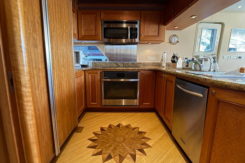 Family Time Yacht Photos Pics Luxurious kitchen interior of 2006 Cheoy Lee 84 Bravo yacht with wood cabinetry and modern appliances.