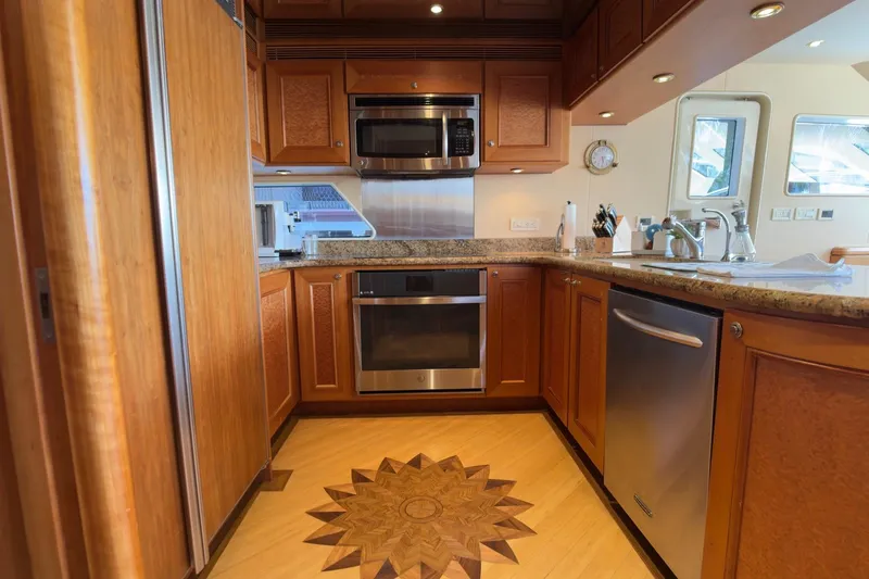 Family Time Yacht Photos Pics Luxurious kitchen interior of 2006 Cheoy Lee 84 Bravo yacht with wood cabinetry and modern appliances.