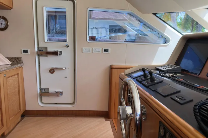 Family Time Yacht Photos Pics Pilothouse interior of 2006 Cheoy Lee 84 Bravo yacht with steering wheel and control panel.