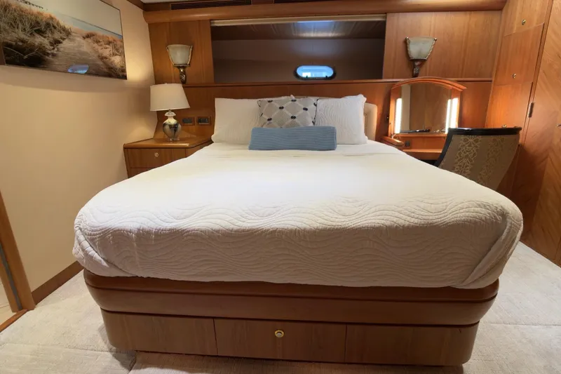 Family Time Yacht Photos Pics Luxurious bedroom interior on 2006 Cheoy Lee 84 Bravo yacht, featuring elegant wood finishes.