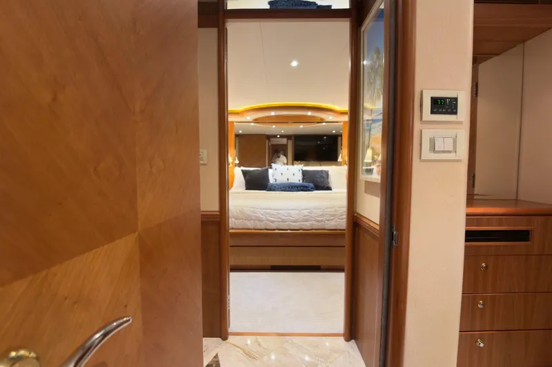 Family Time Yacht Photos Pics Luxurious bedroom interior of 2006 Cheoy Lee 84 Bravo yacht, featuring elegant wood finishes.