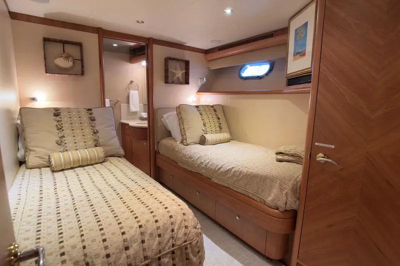 Family Time Yacht Photos Pics Luxurious twin cabin interior of 2006 Cheoy Lee 84 Bravo yacht, featuring elegant bedding and decor.