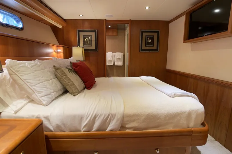 Family Time Yacht Photos Pics Luxurious bedroom interior on 2006 Cheoy Lee 84 Bravo yacht, featuring elegant wood paneling.