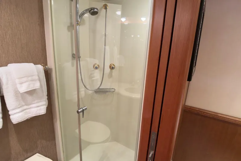 Family Time Yacht Photos Pics Shower area in 2006 Cheoy Lee 84 Bravo yacht bathroom with glass door and towel rack.