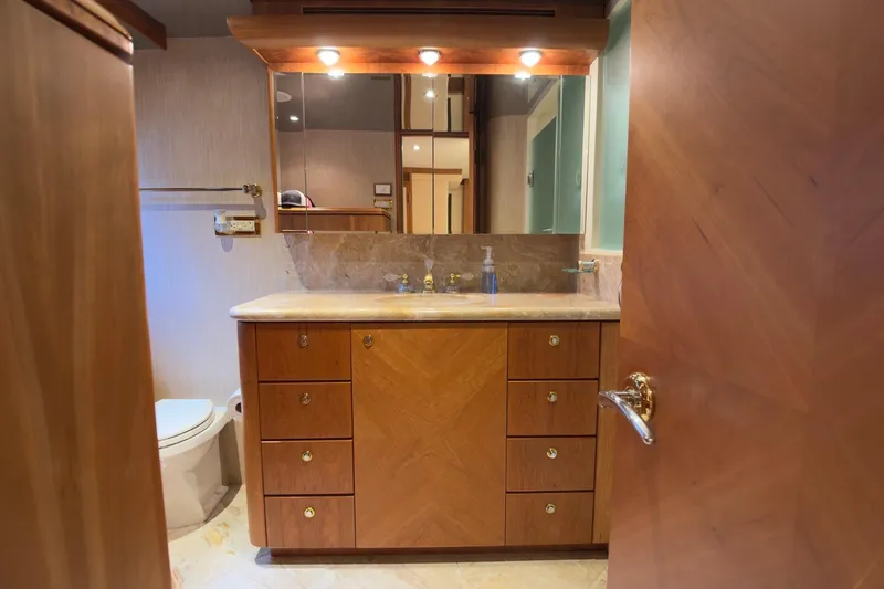 Family Time Yacht Photos Pics Luxurious bathroom interior on 2006 Cheoy Lee 84 Bravo yacht, featuring wooden cabinetry and marble countertop.