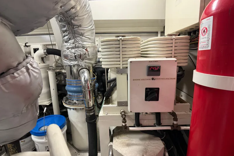 Family Time Yacht Photos Pics Engine room of 2006 Cheoy Lee 84 Bravo yacht with electrical equipment and fire extinguisher.