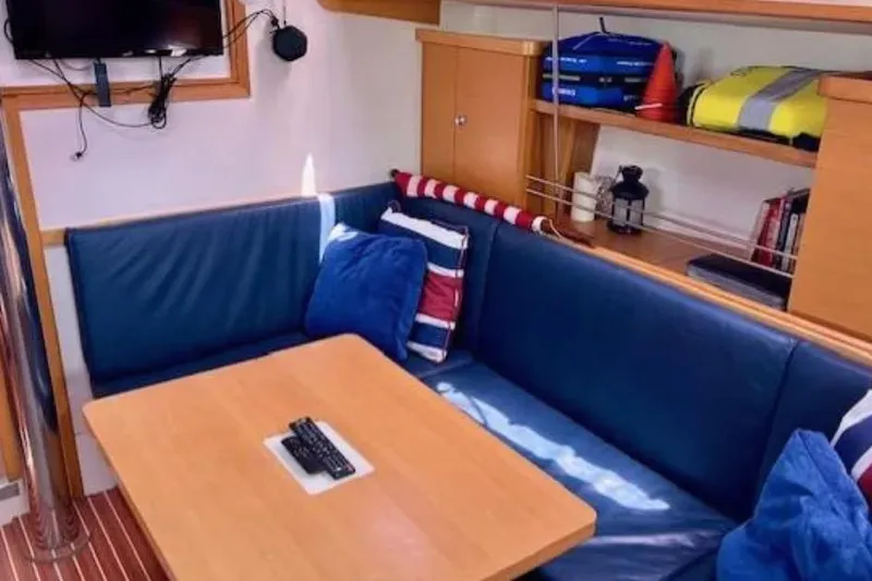Valanta Yacht Photos Pics Cozy interior of 2007 Hanse 400 yacht with blue seating and wooden table.