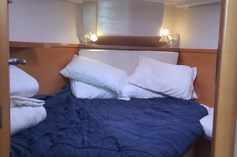 Valanta Yacht Photos Pics Cozy cabin interior of 2007 Hanse 400 yacht with blue bedding and pillows.