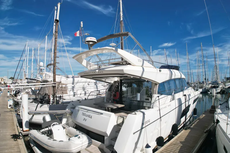  Yacht Photos Pics Prestige 560 Fly 2017 yacht docked at marina, surrounded by sailboats under clear blue sky.